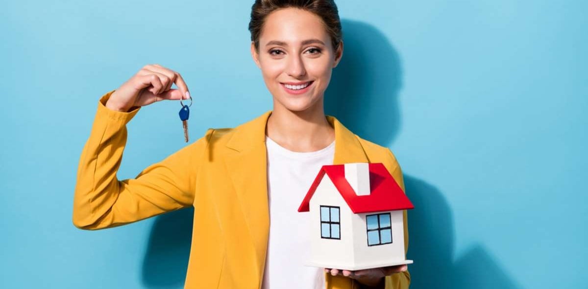 Photo portrait woman in yellow suit smiling keeping key from new house isolated pastel blue color background 6-1